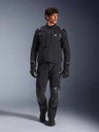 Male model wearing Alpinestars Andes Pro Drystar® XF Jacket, Black and Dark Gray adventure motorcycle jacket, paired with matching technical pants and gloves, featuring multiple pockets and 'Terra' branding on the chest.