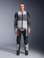 Alpinestars ST-2 Air Jacket, Motorcycle Touring Jacket, Ice Gray Dark Gray and Black, worn by a model with matching adventure pants, featuring large mesh panels, blue Alpinestars logo on chest, and Alpinestars Exploration Equipment branding.