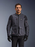 Alpinestars Maxdura Drystar®XF Laminated Armored Shell, Deep Gray and Black adventure motorcycle jacket, front view on model, featuring large cargo pockets, 'All Terra' chest logo, and ventilation zippers, paired with black riding gloves and pants.