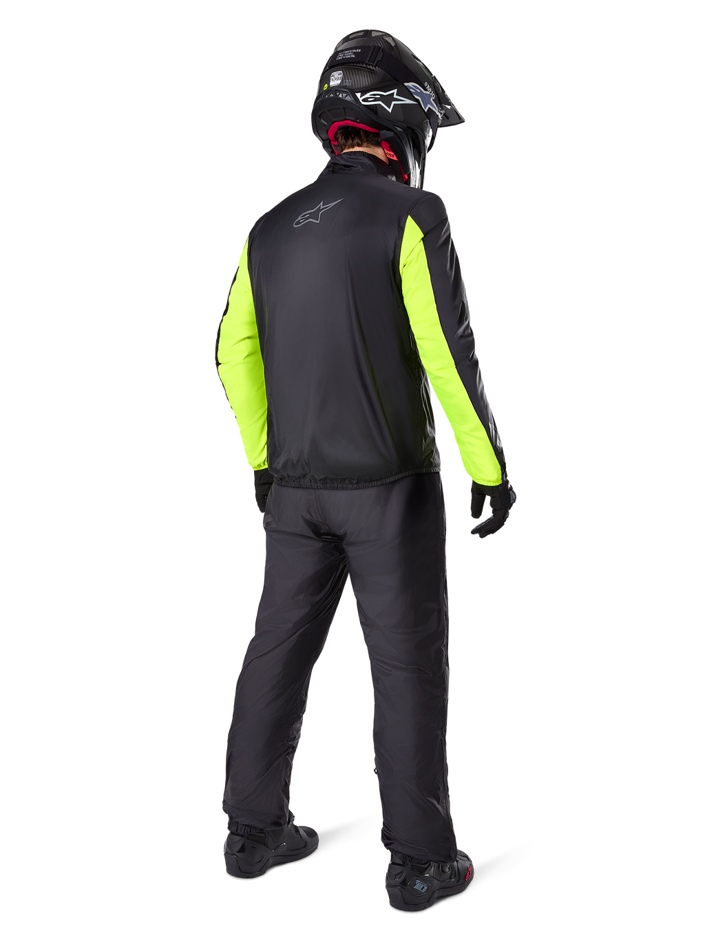 Motorcycle rider seen from the back wearing the Alpinestars Bogotá Pro Drystar® Jacket, Black with bright Yellow Fluo sleeves, matching black pants and helmet, technical all-season adventure gear