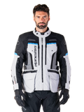Alpinestars Bogota Pro Drystar Jacket, Motorcycle Adventure Touring Jacket, Ice Gray with Black and Cyan blue accents, front view showing ventilation panels and cargo pockets, worn by a model with black riding pants and gloves