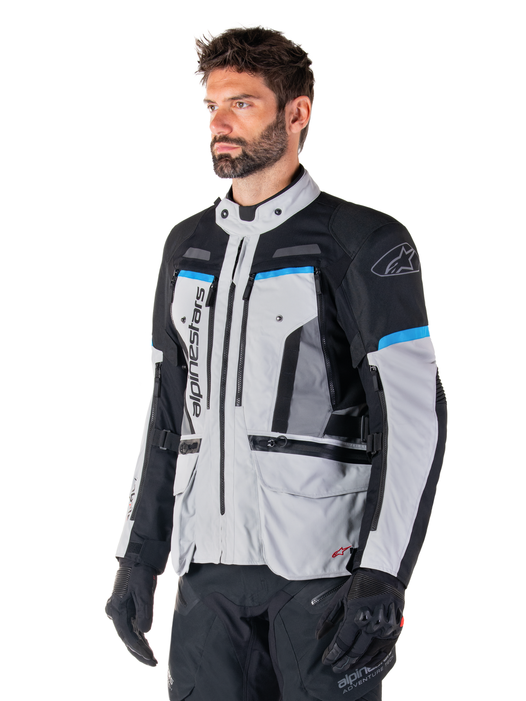 Alpinestars Bogota' Pro Drystar® Jacket, Ice Gray, Black and Cyan, adventure motorcycle jacket worn by a man with black gloves, technical design with multiple pockets and ventilation panels, high-performance riding gear