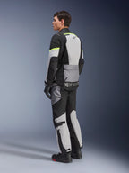 Rider wearing Alpinestars Andes Air Drystar® Jacket and Pants, adventure touring gear in Ice Gray Dark Gray Black with neon yellow accents, featuring extensive mesh panels for airflow, Alpinestars branding on the back, worn with black gloves and boots.