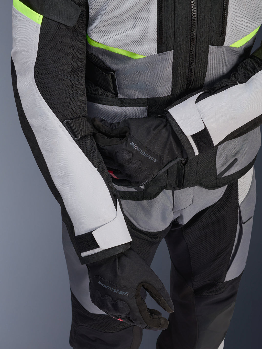 Alpinestars Andes Air Drystar® Jacket, Motorcycle Touring Jacket, Ice Gray and Dark Gray with Neon Yellow accents, close-up showing mesh panels and adjustment straps, worn with black Alpinestars gloves