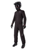 Alpinestars AMT-8 Stretch Drystar XF Liner, full black adventure touring suit, waterproof and windproof jacket and pants, paired with a black adventure helmet, goggles, gloves, and riding boots, featuring AMT logos and Drystar XF branding on sleeves and legs.