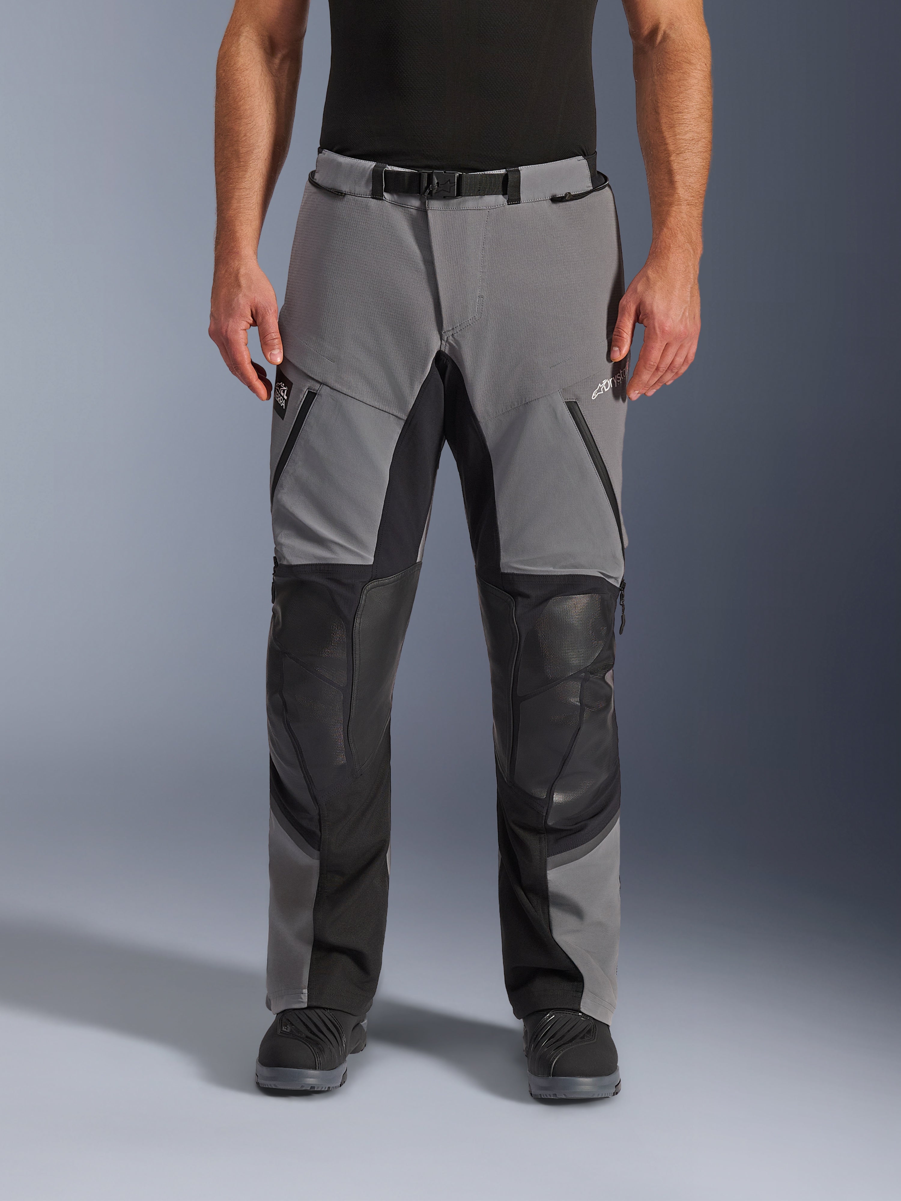 Alpinestars Andes Pro Drystar® XF Pants, Motorcycle Pants, Dark Gray and Black, front view, featuring reinforced black knee panels, waterproof zippers, and magnetic buckle belt, worn with black boots