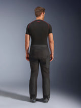 Rider wearing Alpinestars Cusco Drystar® Pants, Black adventure motorcycle pants, back view, paired with a black short-sleeve compression shirt and black riding boots, featuring a durable textile design with articulated panels for touring