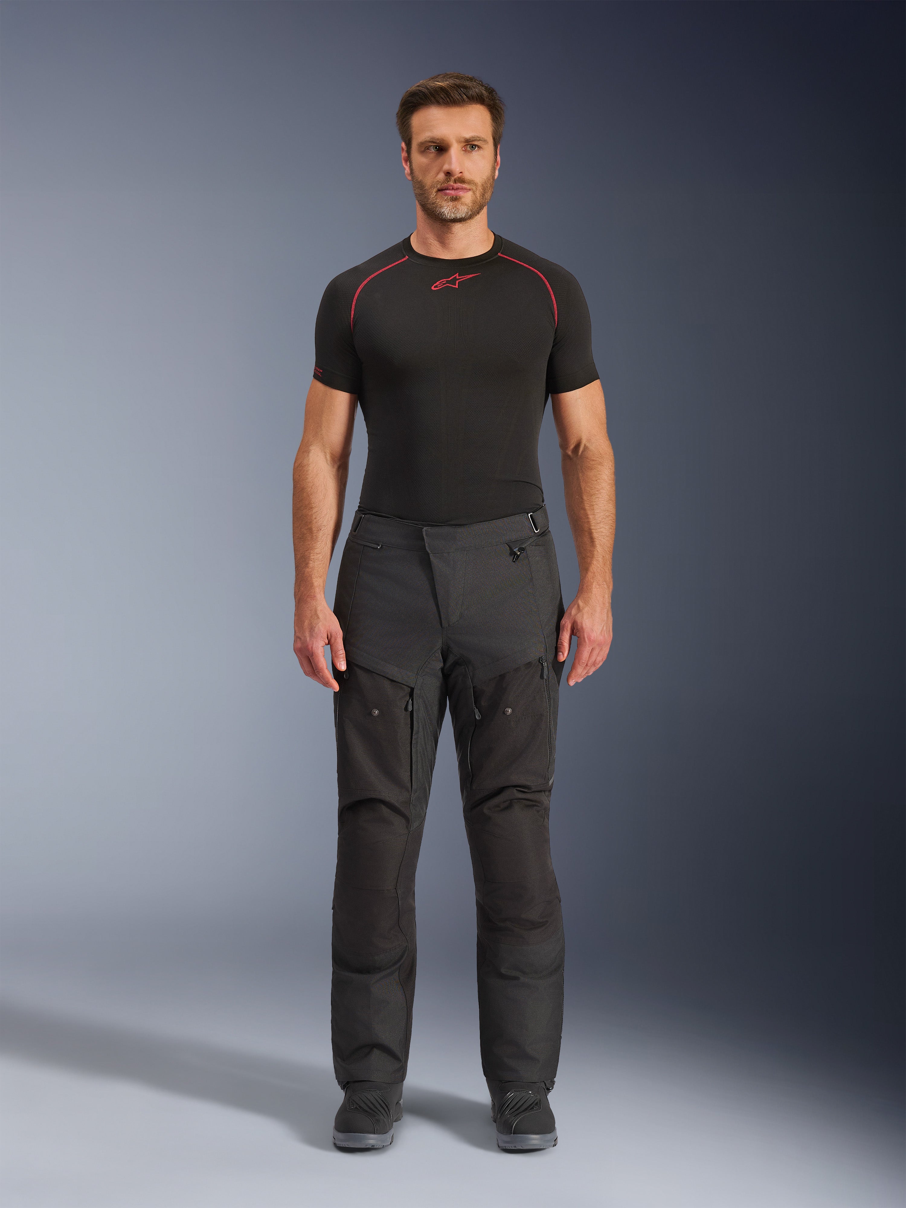Alpinestars Cusco Drystar® Pants, Motorcycle Adventure Pants, Black, full-body front view on male model, featuring zippered thigh ventilation and reinforced textile panels, worn with black Alpinestars base layer