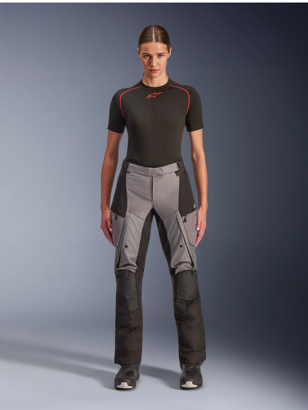 Alpinestars Stella Andes V4 Drystar Pants, Women's Adventure Touring Motorcycle Pants, Black and Dark Gray, worn by a female model with a black base layer and motorcycle boots, featuring reinforced textile panels and cargo pockets for adventure riding