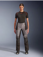 Alpinestars Stella Andes V4 Drystar Pants, Women's Adventure Touring Motorcycle Pants, Black and Dark Gray, worn by a female model with a black base layer and motorcycle boots, featuring reinforced textile panels and cargo pockets for adventure riding