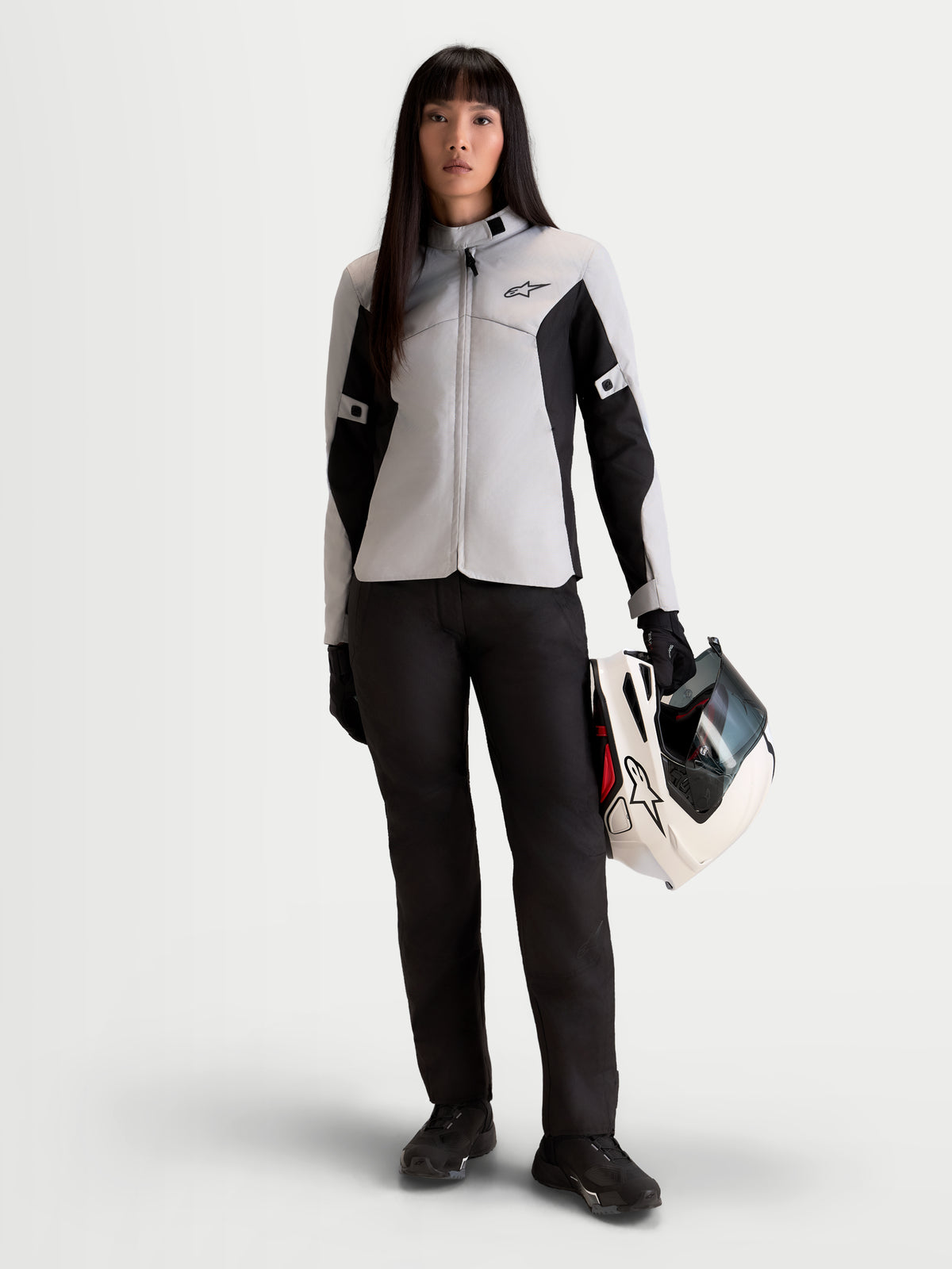Alpinestars Stella C-1 Waterproof Pants, women's urban contemporary motorcycle pants in black, front view on a model wearing matching jacket and holding a helmet, A-class certified weather protection gear