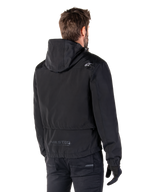 Alpinestars Mootant Waterproof Parka, Black Motorcycle Jacket, Rear view showing hooded design, white logo on shoulder and MO.ST.EQ. reflective branding on lower back, urban contemporary riding gear
