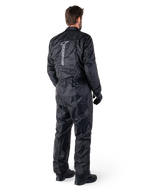 Alpinestars Hurricane Rain V2 Suit, Black one-piece waterproof motorcycle rain suit, back view with large vertical reflective logo, lightweight wind-resistant fabric, worn with black gloves and boots