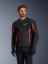 Alpinestars AST V3 Air Jacket, Black Dark Gray and Red Fluo, worn by a man with matching gloves and black pants, featuring technical mesh panels, laser-perforated chest sections, and vibrant red accents, performance sport motorcycle apparel
