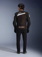 Alpinestars T-GP Plus R V4 Jacket, Black and White sport textile motorcycle jacket, rear view featuring white Alpinestars logo and 'RACING AHEAD' branding, worn with black trousers and boots, streamlined design for performance riding.