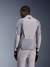 Alpinestars Aeroshell Airflow Jacket in Mid Gray Anthracite, back view showing breathable mesh panels and laser perforations, technical stretch softshell construction with an elongated rear panel, worn with matching gray pants and black gloves for a sport-oriented look.