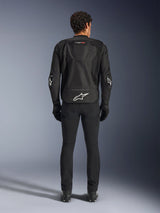 Alpinestars T-GP Air Jacket, Black, Rear view of a man wearing the textile motorcycle jacket, featuring mesh ventilation panels, an aerodynamic hump, and white Alpinestars logos on the lower back and elbows, worn with black riding pants and gloves