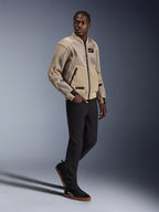 Alpinestars Flight Air Jacket, Urban Motorcycle Jacket, Aluminum color, worn by model with black pants and black sneakers, featuring 3D mesh ventilation panels and a bomber-style design, modern street style for urban riding.