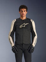 Alpinestars T-SPS Air V2 Jacket, Motorcycle Riding Jacket, Black and Mastic Aluminum, male model wearing jacket with black pants and gloves, featuring mesh panels for ventilation, large Alpinestars logo on the chest, and sporty fitted design
