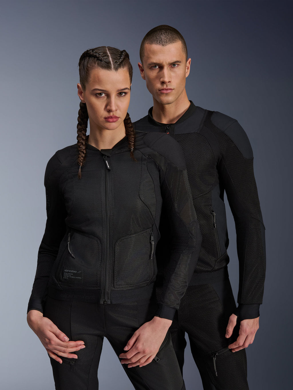 Alpinestars Troop-Air Pro Jacket, Black technical armored air jackets worn by male and female models, featuring breathable mesh panels and integrated protection, urban motorcycle gear designed for warm-weather riding.