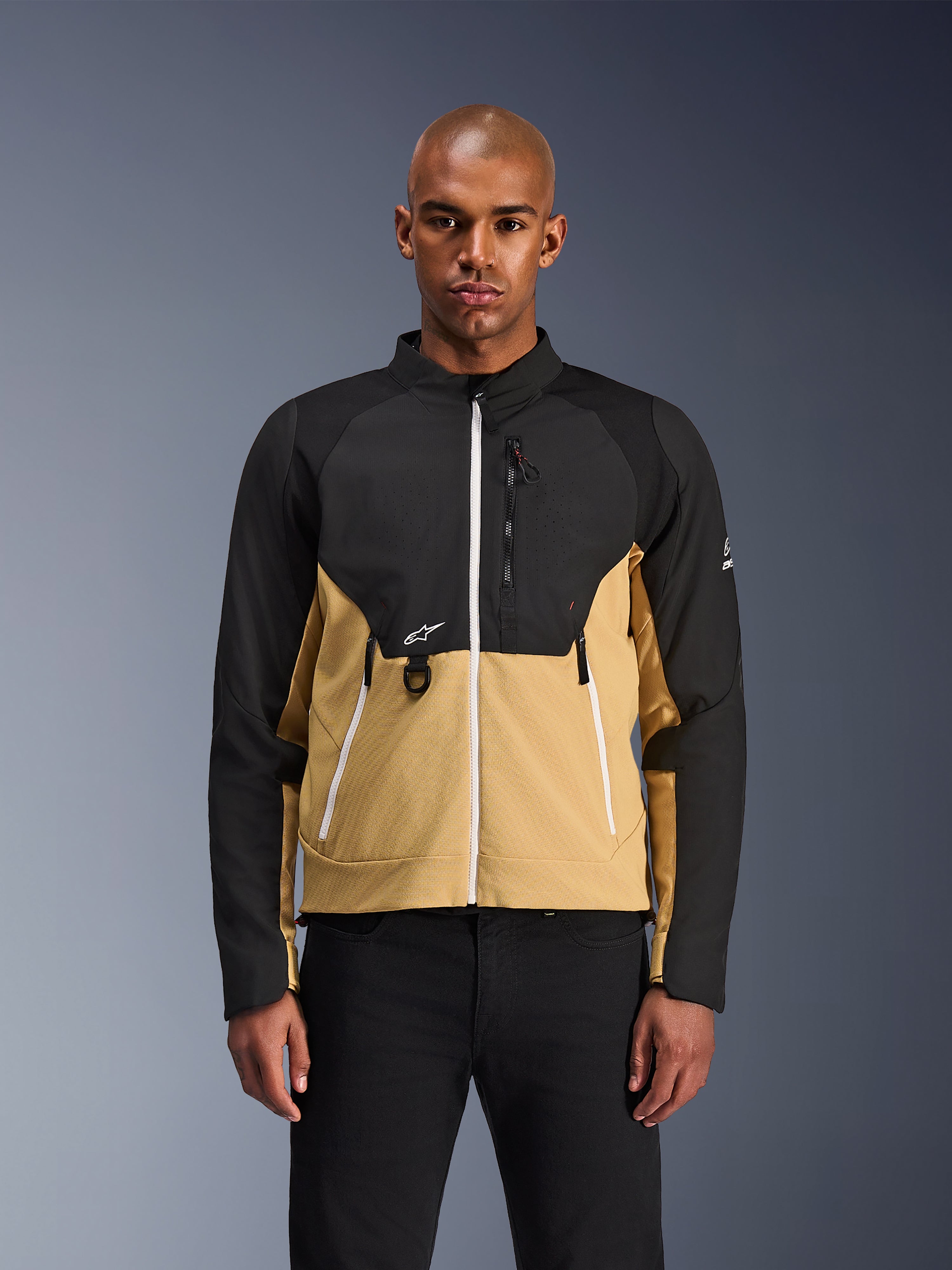 Alpinestars Provoke Jacket, Urban Motorcycle Jacket, Black and Camel, front view on a male model, featuring a two-tone design with white zippers, zippered chest pocket with D-ring, and small white Alpinestars logo, contemporary urban rider apparel.