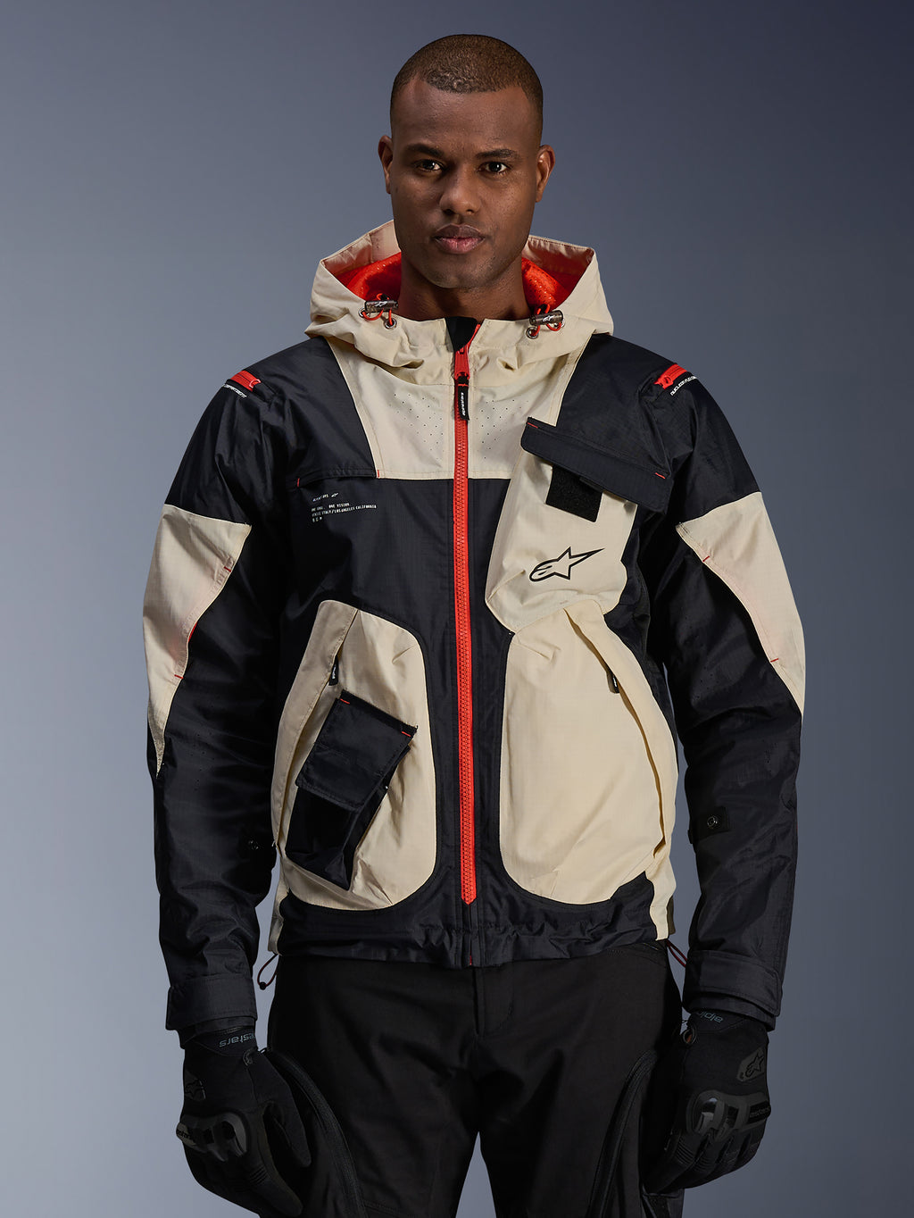 Alpinestars Mogress Air Jacket, urban road motorcycle jacket, Almond and Black with Hot Orange zippers and hood lining, hooded design with utility pockets, chest logo, worn with black gloves