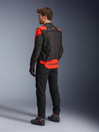 Man wearing Alpinestars T-Stunt Air Jacket from the back, Black Red Fluo and Dark Red, textile motorcycle jacket with mesh panels and sport-cut design, featuring bold Alpinestars branding on the lower back, styled with black pants and riding boots