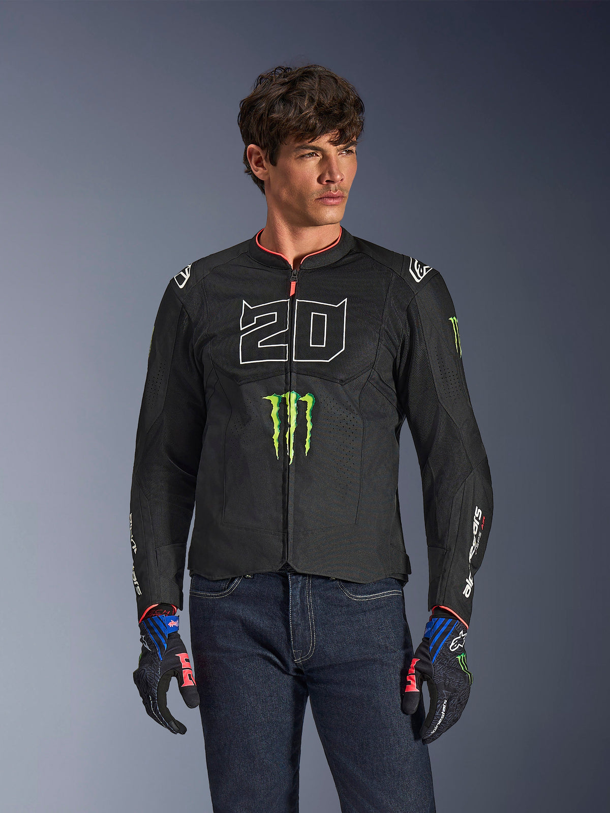 Alpinestars FQ20 T-SPS Air V2 Monster Jacket, Black motorcycle jacket with large white '20' and green Monster Energy logo, worn by a male model with dark jeans and matching gloves, lightweight mesh construction for urban riding