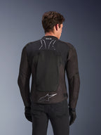 Alpinestars SMX Air Jacket in Black Anthracite, rear view on a model, featuring a large tech mesh back panel for ventilation, Tech-Air Ready branding on the collar, and a silver Astar logo on the lower back, paired with black gloves and riding trousers.