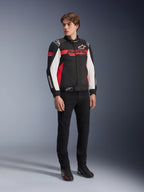Alpinestars Monza Sport Jacket, Black Bright Red and White, textile motorcycle jacket, racing-inspired design with ASTARS branding across the chest and sleeves, worn by a model with black pants and riding shoes, casual sport riding gear
