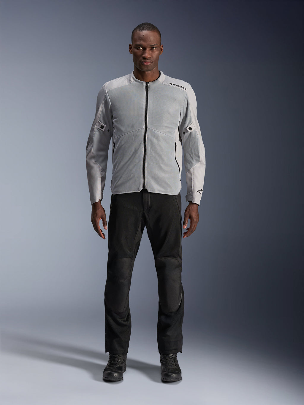 Alpinestars C-1 Air Jacket in Silver, men's urban textile motorcycle jacket with ventilated mesh panels, worn by a model with black riding pants and black boots, contemporary commuting style