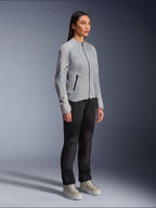 Woman wearing the Alpinestars Stella C-1 Air Jacket in Silver, lightweight textile and mesh motorcycle jacket, styled with black riding pants and casual sneakers, clean urban riding aesthetic.