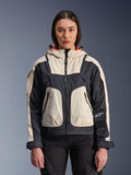 Alpinestars Molly Air Jacket, Women's Motorcycle Urban Jacket, Black Almond, front view on a model, featuring cream and black ripstop panels, hood with orange lining, front zipper closure, and large utility pockets, contemporary streetwear-inspired motorcycle gear