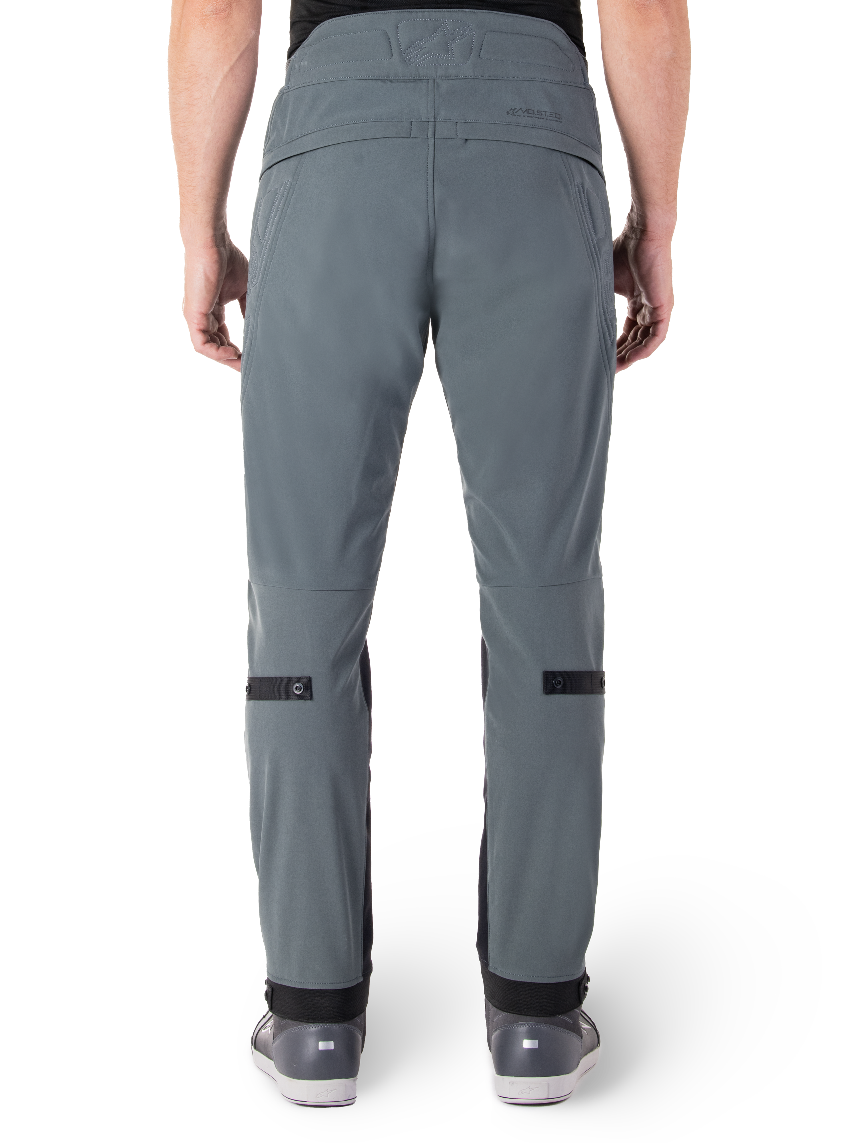 Alpinestars Alden Pants, Urban Gray, rear view of men's urban motorcycle pants, slim fit below the knee with black calf adjustment straps, high-waisted design featuring MO.ST.EQ. wordmark on the back yoke, worn with gray riding shoes