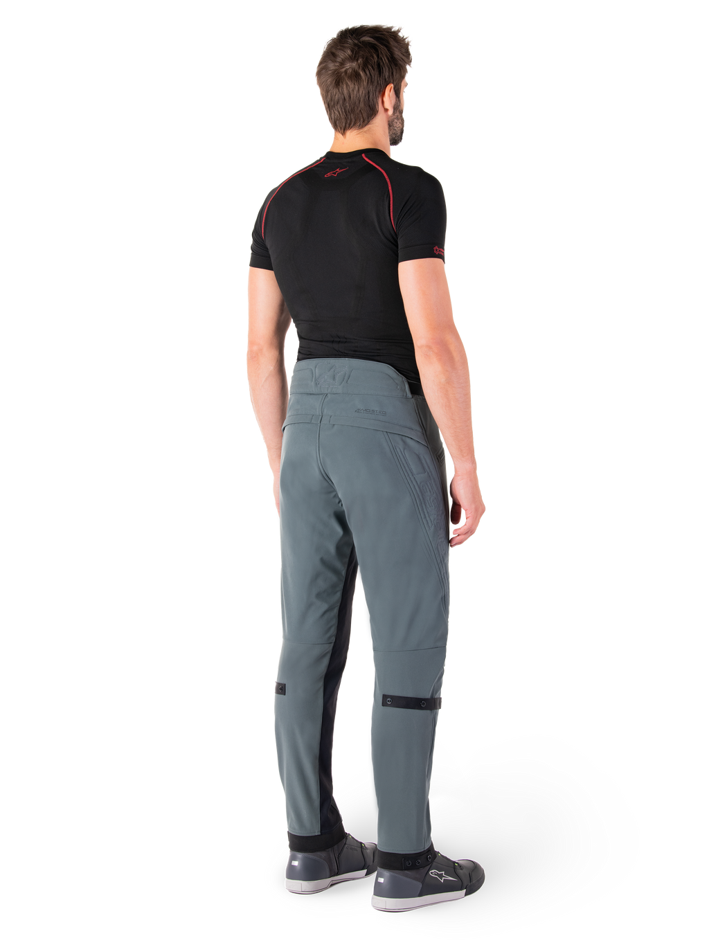 Alpinestars Alden Pants, Urban Gray, rear view, technical textile motorcycle pants with quilted detailing on the upper back waist and legs, paired with a black base layer and gray riding shoes, contemporary urban streetwear style.