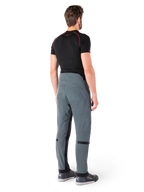 Alpinestars Alden Pants, Urban Gray, rear view, technical textile motorcycle pants with quilted detailing on the upper back waist and legs, paired with a black base layer and gray riding shoes, contemporary urban streetwear style.