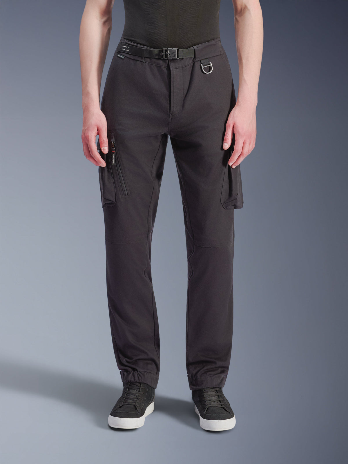Alpinestars Flex-AST Cargo Pants - Short, Black urban motorcycle pants, front view featuring technical stretch fabric, multiple cargo pockets with zippered side detail, metal D-ring belt loop, regular tapered fit with elasticated hems, worn with black sneakers