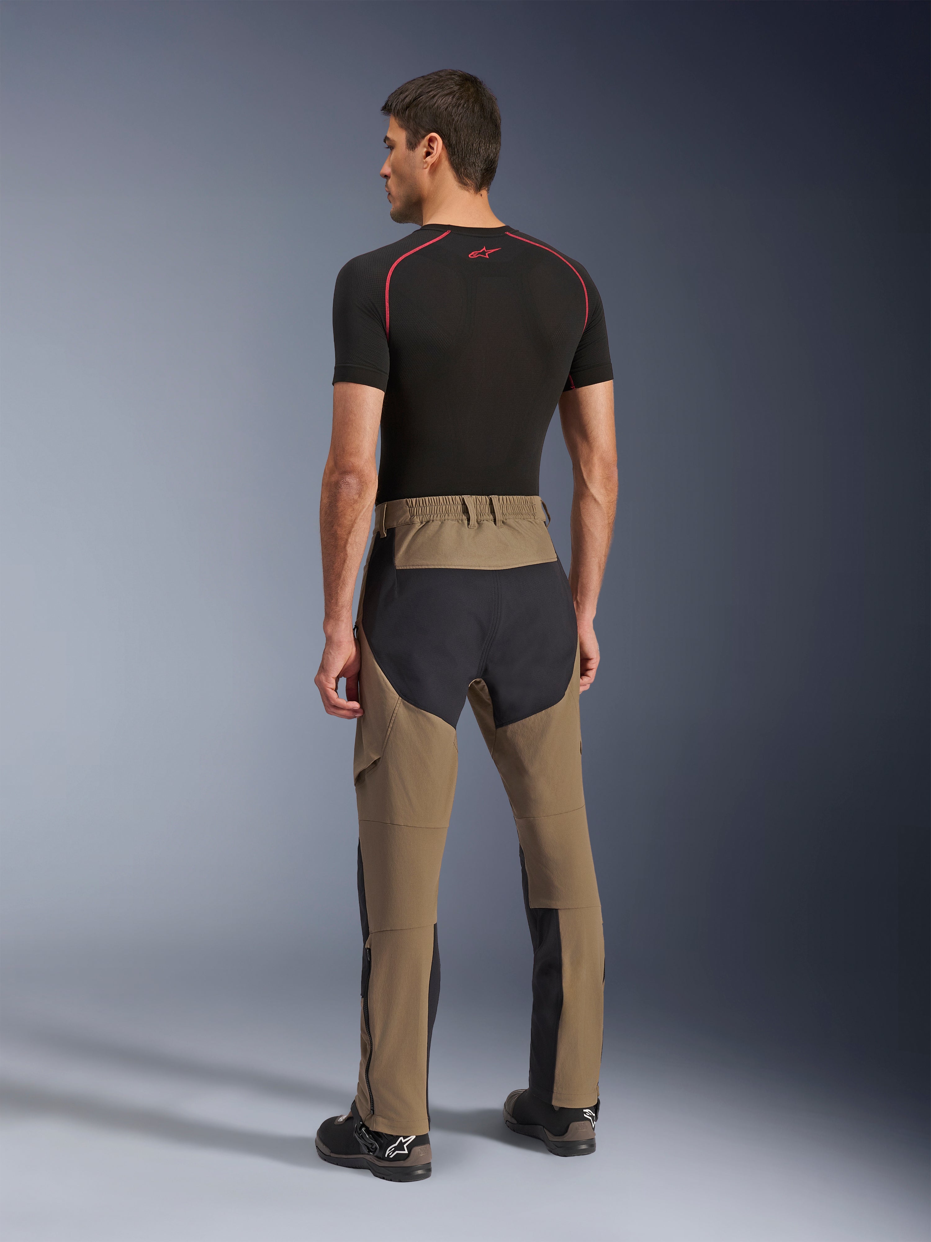 Alpinestars Flex-AST Explorer Pants, Adventure Motorcycle Pants, Walnut Black, rear view on model showing black ripstop seat and leg panels, stretch textile construction, and long lower-leg zippers for adventure touring