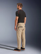 Alpinestars Flex-AST Canvas Pants, Brown, back view showing zippered pockets, workwear-inspired hammer loop, and snap closures at leg openings, worn with a black base layer and black sneakers, urban motorcycle style