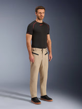 Alpinestars Flex-AST Canvas Pants, Urban Motorcycle Pants, Brown, full-body studio shot of a man wearing the pants with a black performance t-shirt and black sneakers, featuring heritage workwear styling, zippered front pockets, and a durable polycotton twill construction.