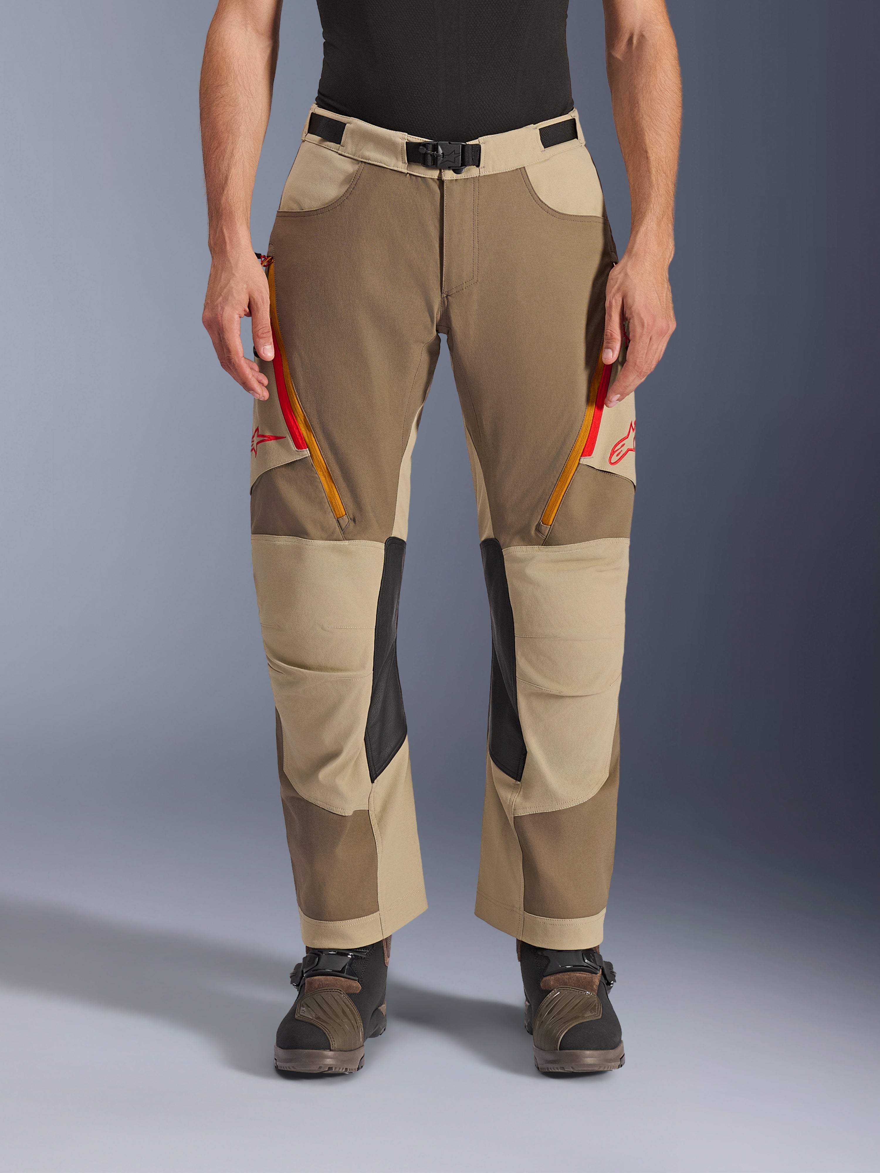 Alpinestars Maxdura Dual Pants, Walnut Aluminum, adventure motorcycle pants featuring red and orange zippered thigh vents, black leather inner knee panels, worn with a black base layer and rugged boots, durable multi-tonal design for dual-sport riding