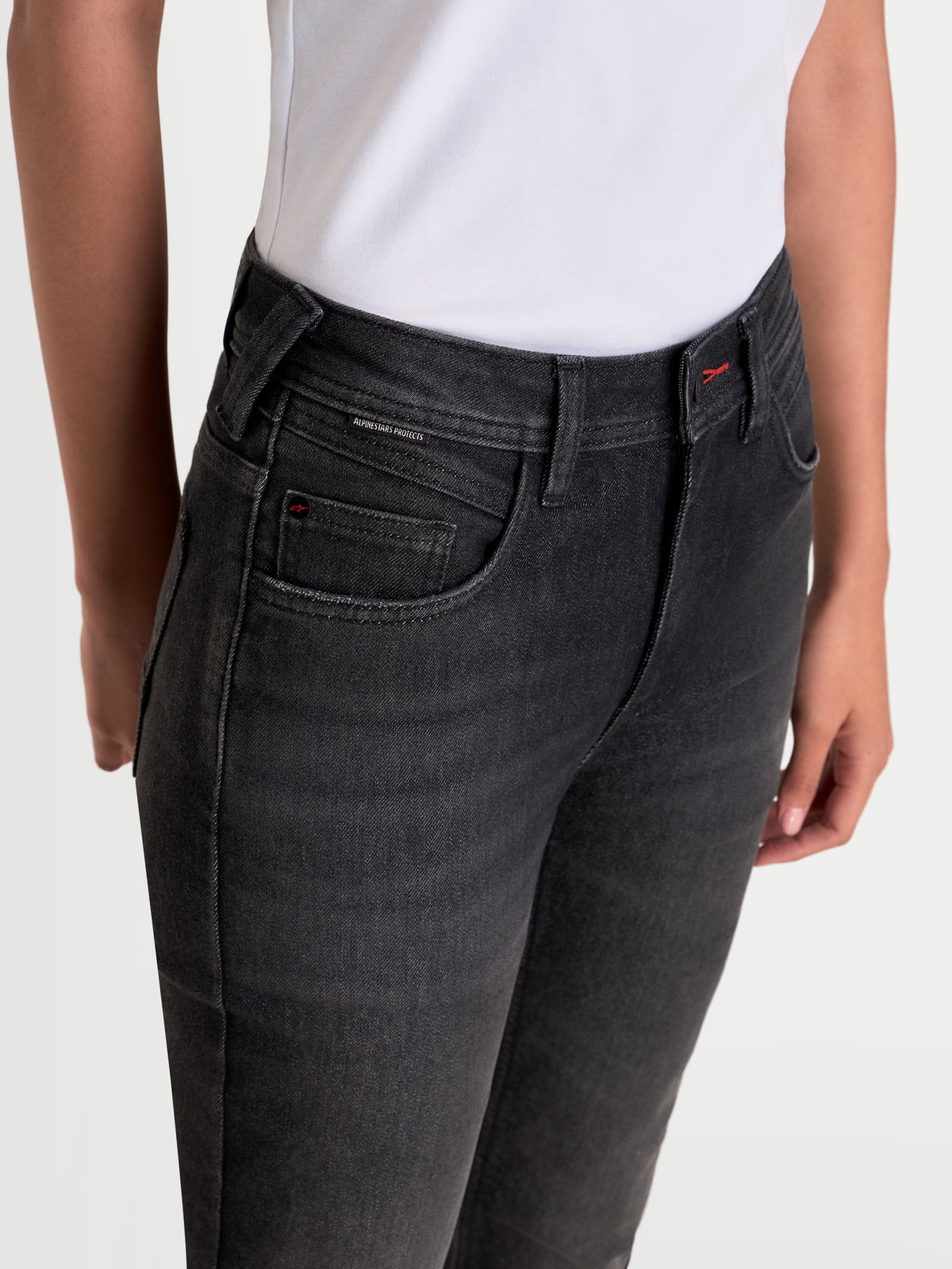 Alpinestars Stella Flex-AST 7 Denim Pants, women's urban motorcycle denim pants in faded black, close-up waist and pocket detail showing five-pocket construction worn by a model