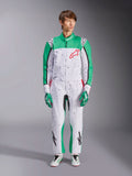Alpinestars KMX-9 V3 Graphic 6 Suit, White Green and Red, one-piece karting suit featuring a black splatter graphic pattern, green panels on sleeves and legs, red Alpinestars chest logo, worn with matching racing gloves and shoes