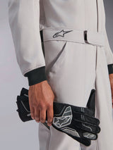 Alpinestars GP Race V3 Suit FIA, Auto Racing Suit, Silver Anthracite, held with black racing gloves, featuring adjustable belted waist with embroidered star logo, black ribbed cuffs, clean and professional motorsport design