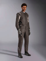 Male racer wearing Alpinestars GP Race V3 Suit FIA, Black and Silver auto racing suit, complete with matching gloves and shoes, featuring silver accents on the shoulders and lower leg, professional automotive racing gear with a tailored fit