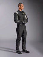 Male driver wearing the Alpinestars Limited Edition Lamborghini GP Tech V4 Suit, FIA-certified auto racing suit in Black, Silver, and Gold, paired with matching racing gloves and shoes, featuring Lamborghini Squadra Corse branding, professional motorsport racing gear