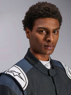 Alpinestars GP Pro Comp V2 FIA Suit, men's auto racing gear in Black and Asphalt with white logo shoulder epaulettes.