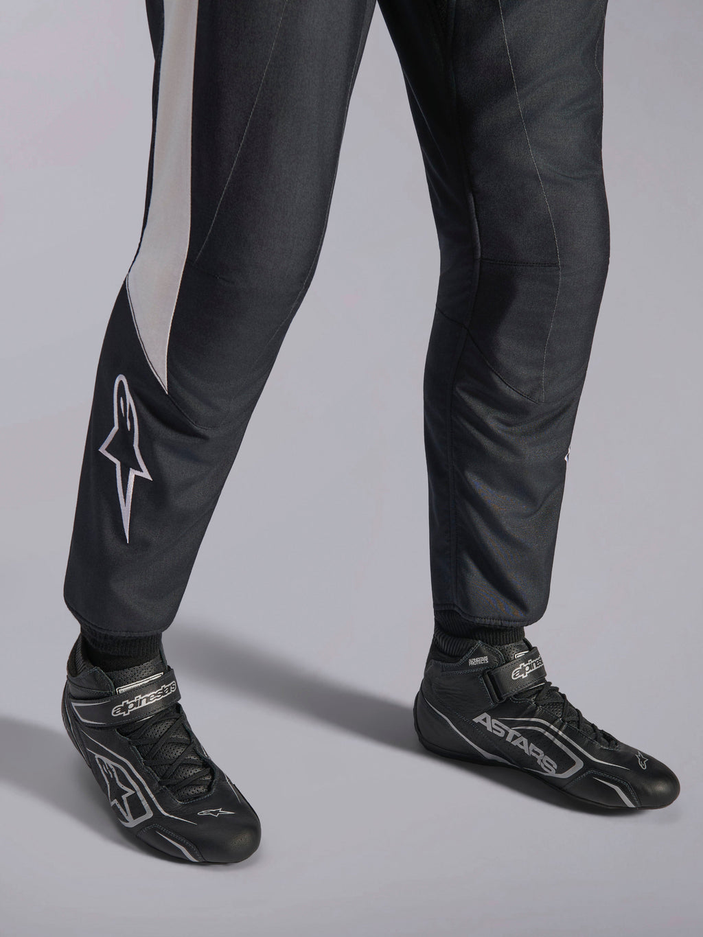Alpinestars GP Pro Comp V2 FIA Suit, black and white auto racing gear with matched ASTARS professional racing boots.