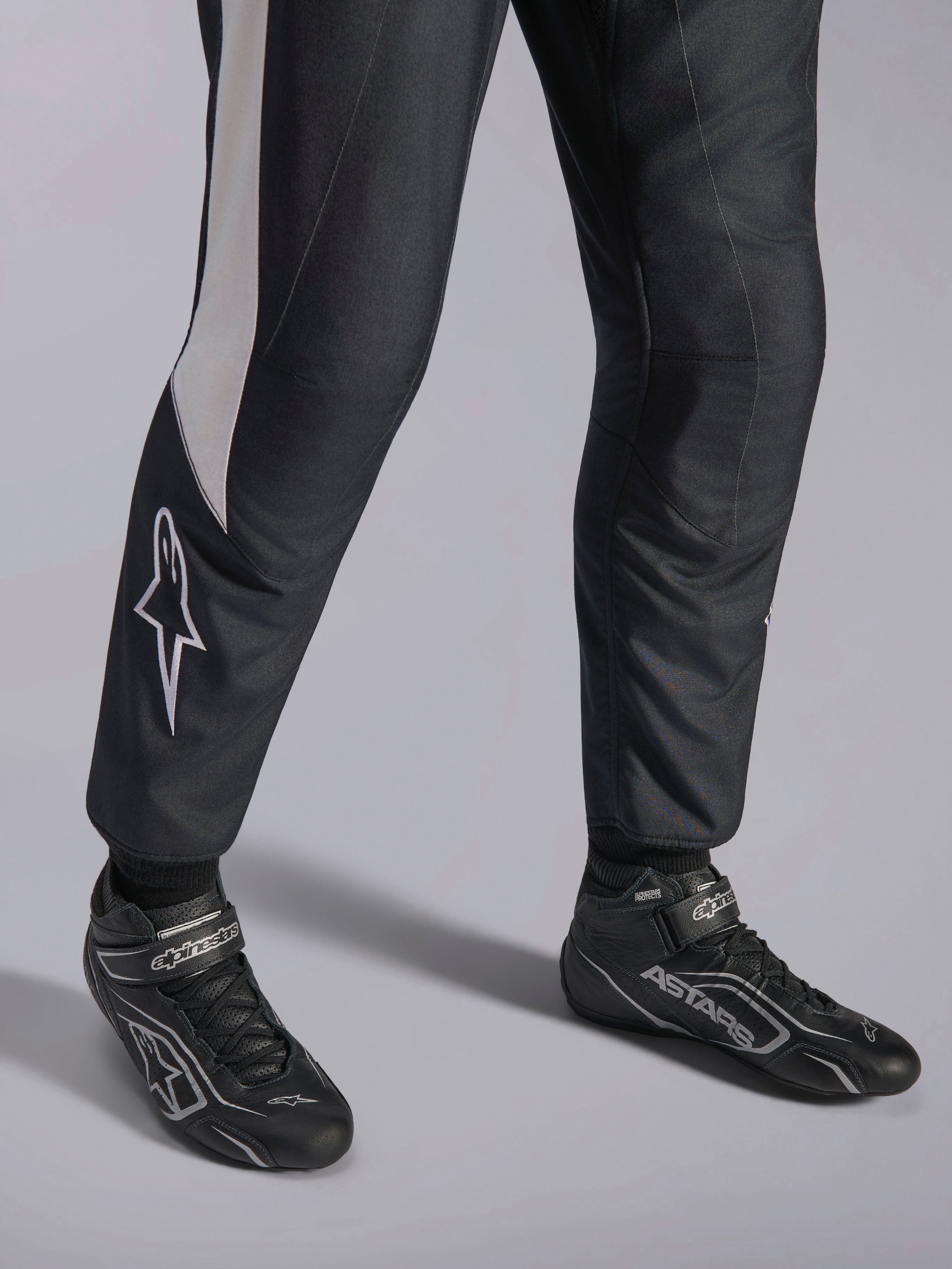 Alpinestars GP Pro Comp V2 FIA Suit, black and white auto racing gear with matched ASTARS professional racing boots.