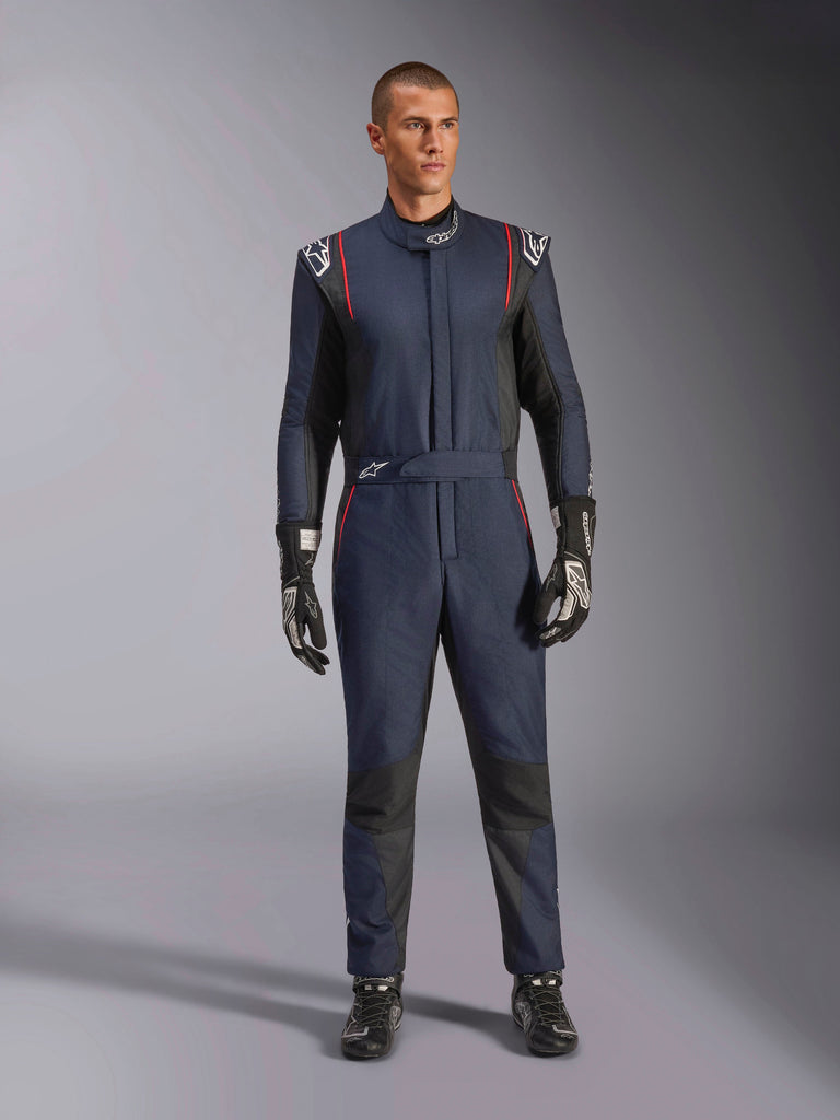 Alpinestars GP Tech V4 Suit, professional auto racing suit in Blue Navy and Black with Red piping, one-piece FIA certified racing gear, worn with black racing gloves and footwear, motorsport driver apparel
